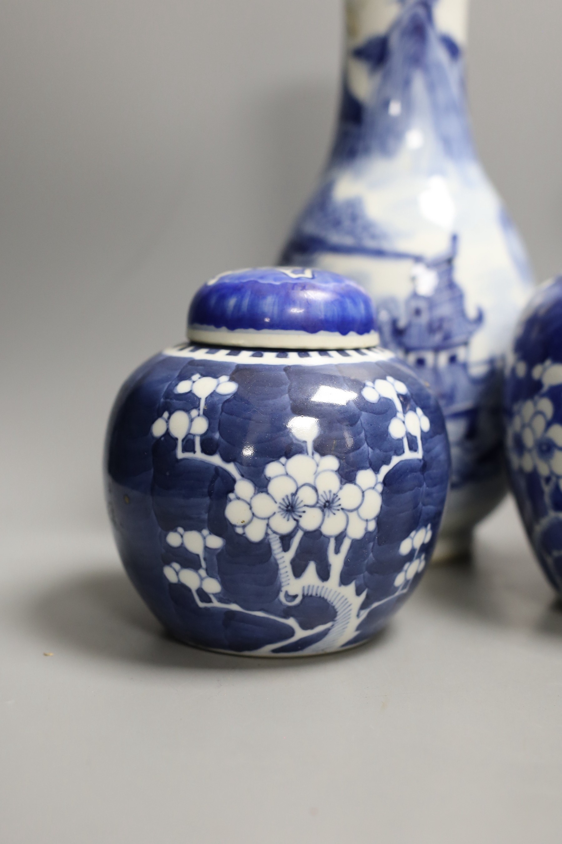 A 19th century Chinese blue and white ‘landscape’ vase, an early 20th century blue and white sleeve vase and three blue and white jars and covers. Tallest 25.5cm